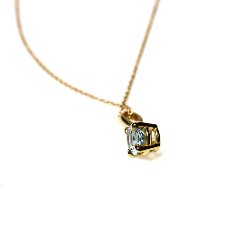 Brilliant cut small 5mm blue aquamarine set in an 18kt yellow gold pendant. The pendant is hung on a fine 18kt yellow gold chain made in Italy.
