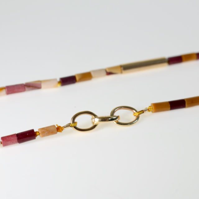 Cylinder shaped Australian jasper beads in mustard/white/red multi colours are hand knotted on thread with 14kt yellow gold beads and completed with an 18kt yellow gold clasp. By jewellery designer Tamahra Prowse.