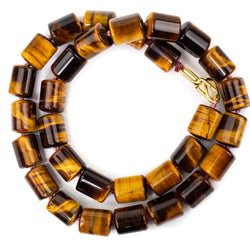A chunky necklace made from luminous tiger eye beads. Cylinder shaped at 10 x 13mm, necklace is 46cm long and hand knotted on dusty pink silk thread with an 18kt gold clasp.
