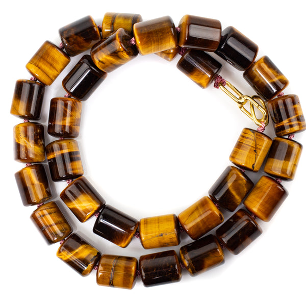 A chunky necklace made from luminous tiger eye beads. Cylinder shaped at 10 x 13mm, necklace is 46cm long and hand knotted on dusty pink silk thread with an 18kt gold clasp.